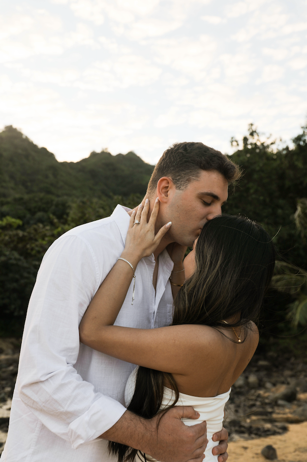 Couple kissing closely on the beach at golden hour, Kauaʻi