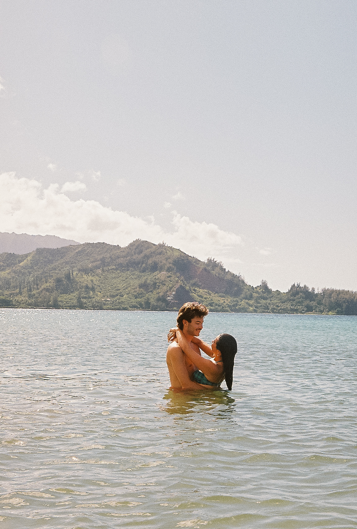 Couple embracing in Hanalei Bay water, Kauaʻi