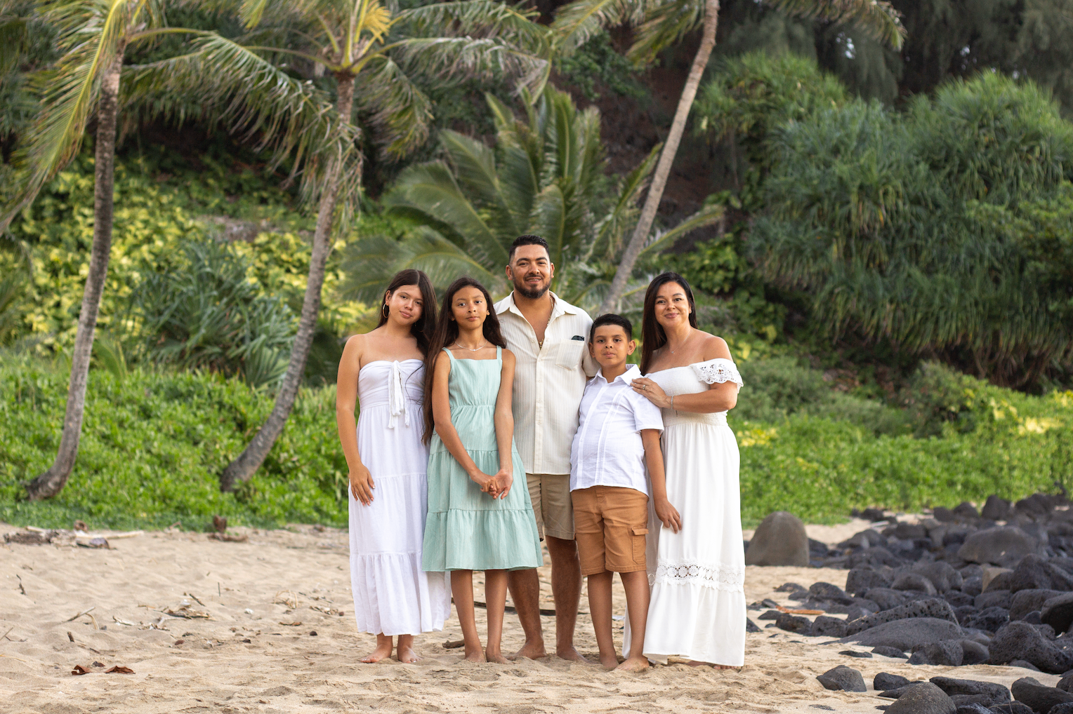Family of five standing together on a Kauaʻi beach