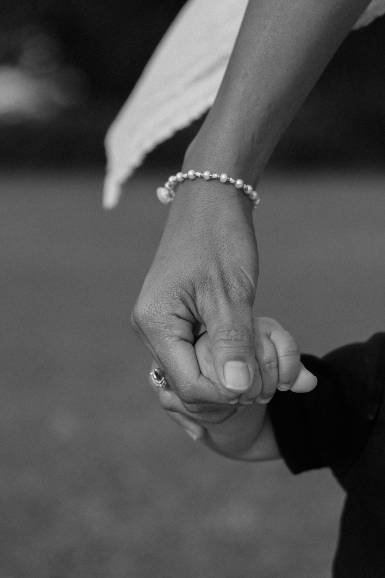Black and white close-up of a parent holding a child's hand