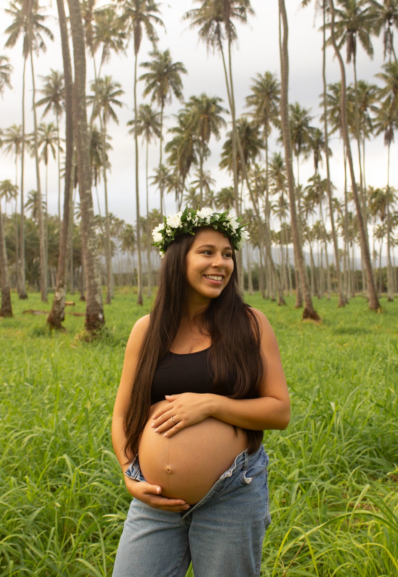 Maternity portrait with haku lei among tall coconut palms, Kauaʻi