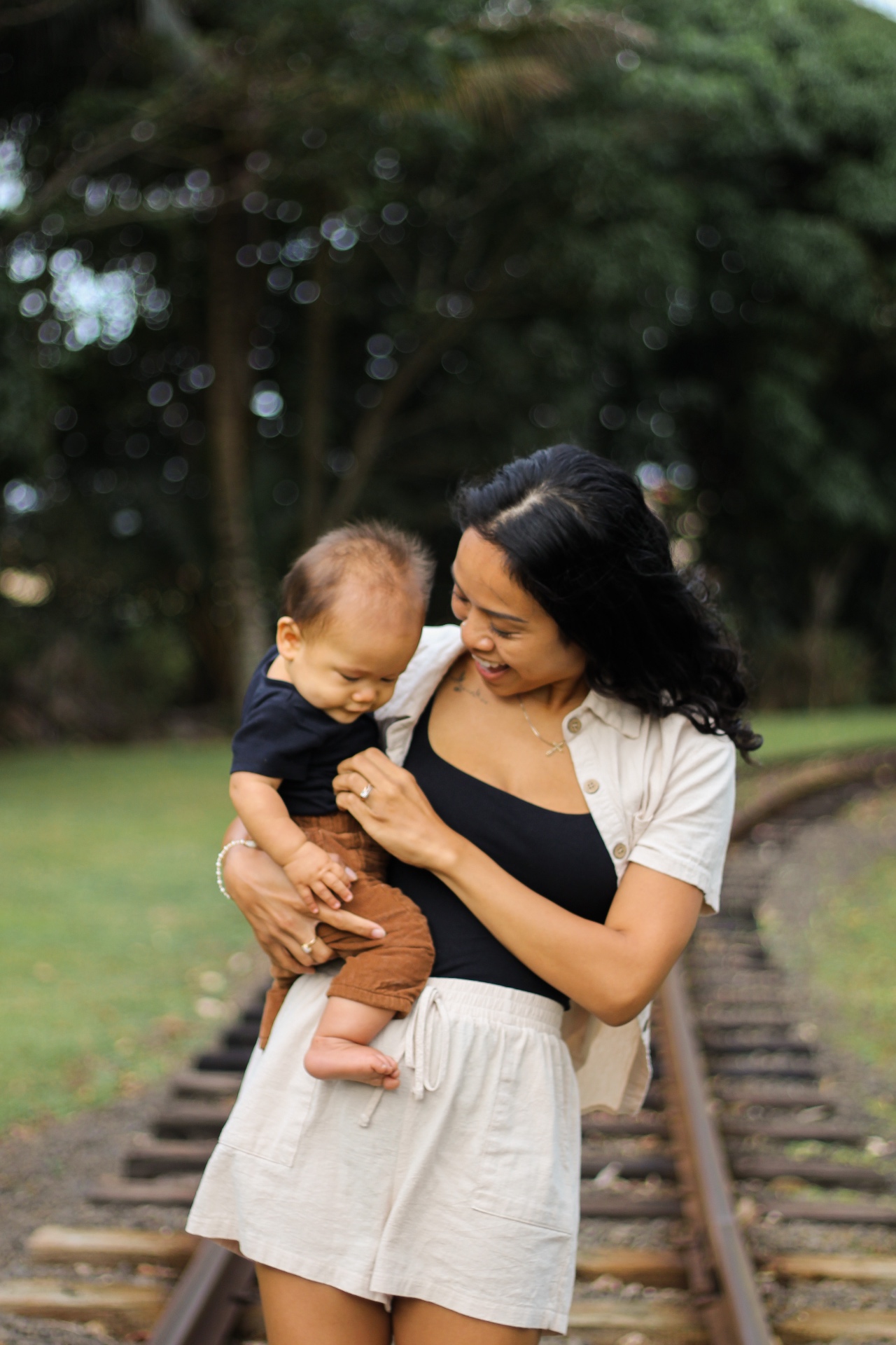 Mother holding her baby on old railroad tracks