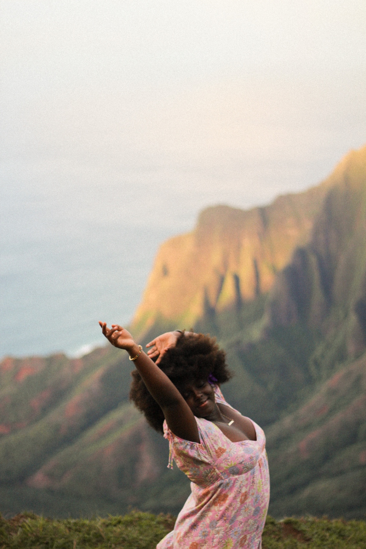 Joyful portrait with Nāpali Coast cliffs at golden hour, Kauaʻi